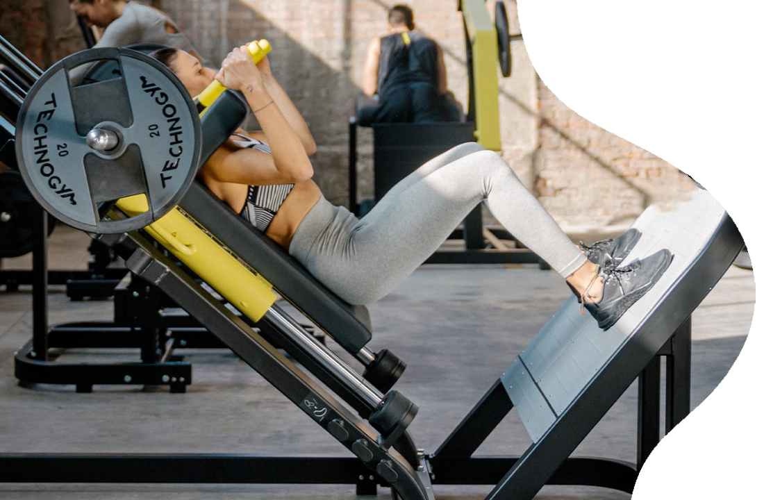 A woman is using an exercise machine in the gym.