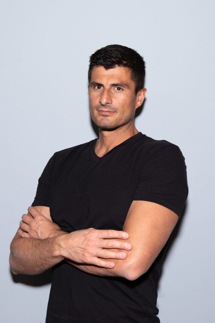 Man in black shirt with arms crossed.