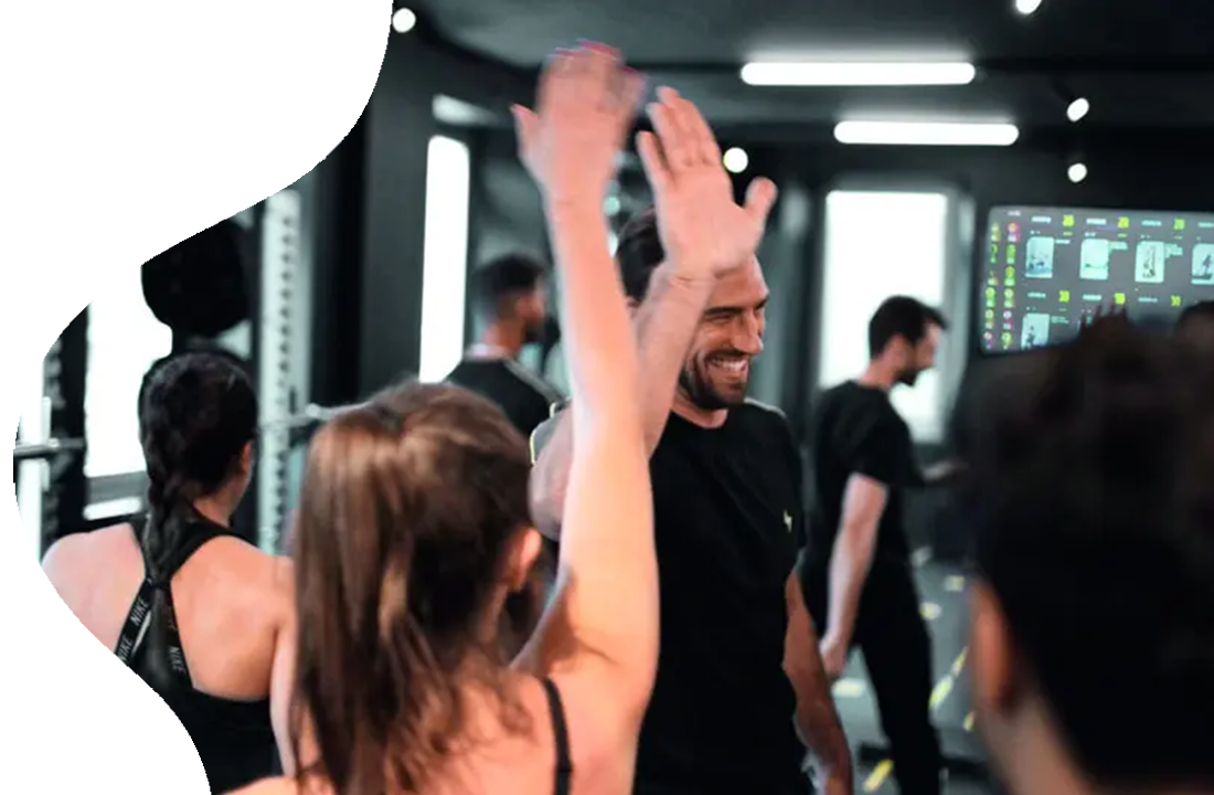 Group of people high fiving in gym.